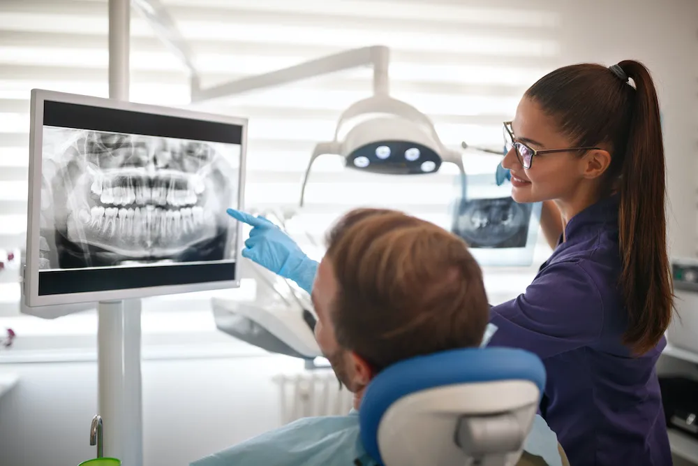 Dentist showing x-ray footage of teeth to patient