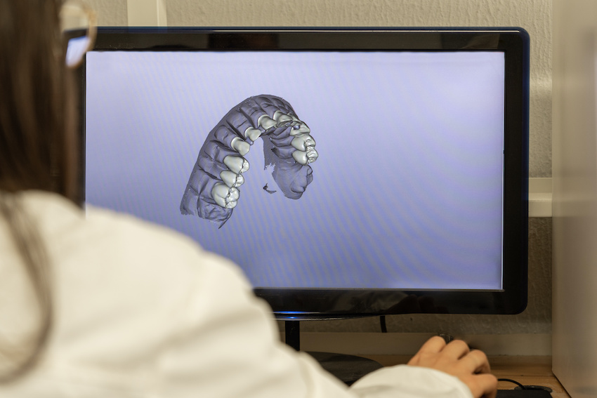 Woman working on computer with dental software platform